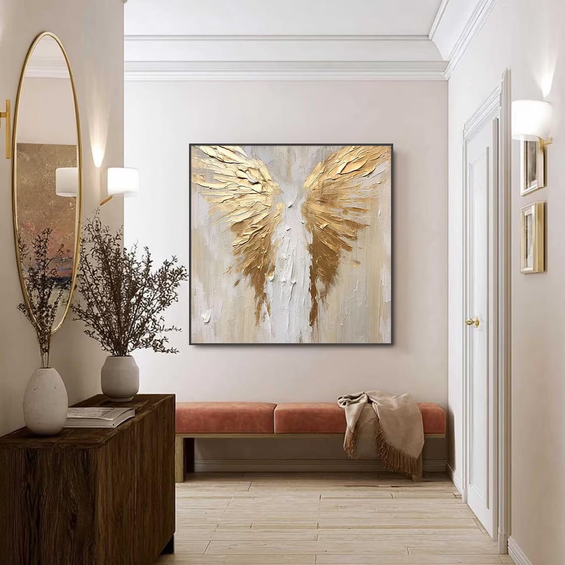 A textured gold-winged painting with visible brush-strokes, framed and hung above a bench in a bright hallway